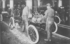 Workers install engines on Model Ts at a Ford Motor Company plant. The photo is from about 1917.