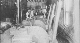 Workers sit astride their grinding wheels in this photo from the Rockford (III.) Cutlery Co., taken about 1900.