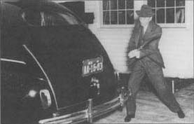 Henry Ford demonstrates the durability of automobile components made from saybeans by striking the trunk of a car with an axe. (From the collections of Henry Ford Museum & Greenfield village.)